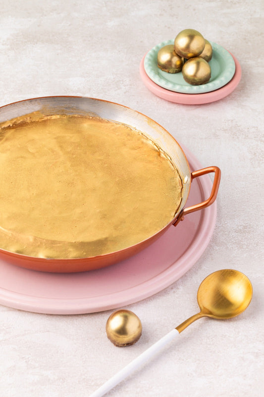 Panelinha de cobre com a casquinha dourada inteira, servida em prato rosa